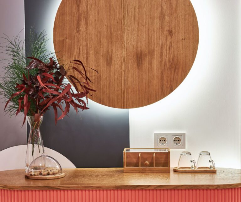 red bamboo desk with plant and wall hanging